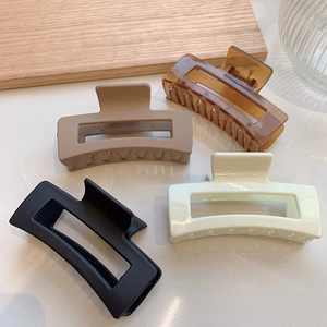 Detailed view of four elegant square hair claws in amber, khaki, black and cream colors