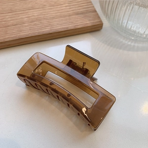 Detail shot of a rectangular amber hair claw clip with a strong metal spring mechanism