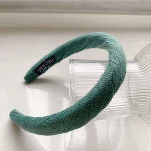 Détail du serre-tête en tricot vert foncé avec étiquette faite main de haute qualité