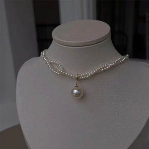 Zweireihige kleine Perlenkette mit großem runden Perlenanhänger im goldenen Vintage-Stil