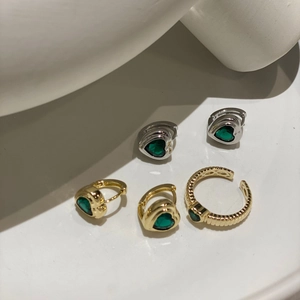 Detailliertes Set aus gedrehtem Goldring und herzförmigen grünen Zirkon-Ohrringen