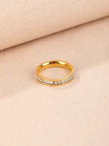 Macro shot of gold eternity ring with square-cut zircons and polished finish