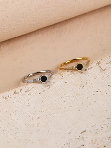 Close-up of titanium steel rings featuring black circular inlays and micro-set crystals