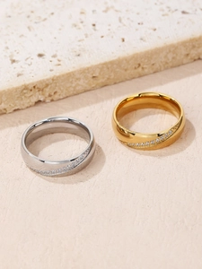 Dettaglio macro di anelli di coppia color oro e argento con piccoli cristalli diagonali