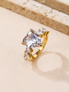 Makroaufnahme von Goldring mit herzförmigem Zirkon auf Naturstein mit feiner Fassung