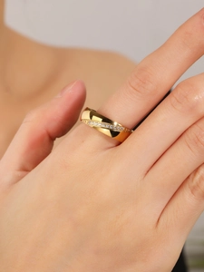 Dettaglio di un anello d'oro stile francese con pavé di diamanti intrecciato sulla mano