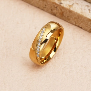Anello dorato stile francese con fila di zirconi bianchi su superficie in pietra