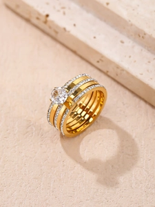 Vue détaillée bague en titane doré à trois rangs sertie de cristaux de zircone brillants