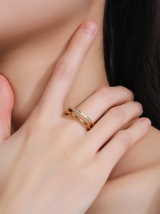 Close-up of double-layer titanium steel ring with micro-pave crystals in golden finish