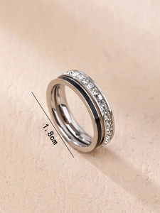 Primer plano de anillo de doble capa con metal plateado y piedras de circonita blanca