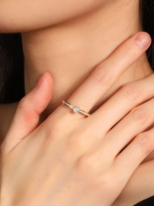Primo piano di un anello di lusso con diamante a sei griffe al dito con dettagli in oro