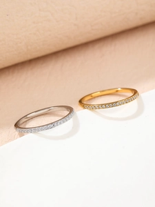 Close-up of minimalist half-eternity titanium steel rings in silver and gold finishes
