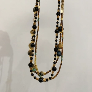 Dettaglio collana multistrato con pietre occhio di tigre, onice e perle vere