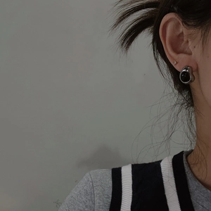Detalle de pendiente estilo lava con piedra negra en la oreja de una modelo
