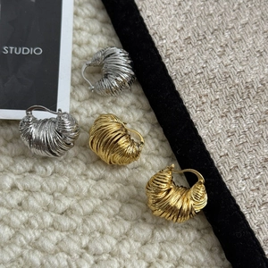 Macro di orecchini a corno a forma di U in oro e argento con design a spirale intrecciata