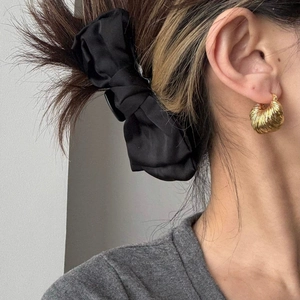 Dettagli di orecchini a cerchio dorati testurizzati a U e clip per capelli in raso nero