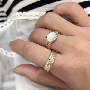 Brass gold plated feather ring set with white cat eye stone and irregular texture design