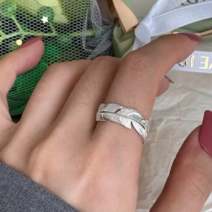 Close-up of adjustable brass feather ring with gold plating on model's finger