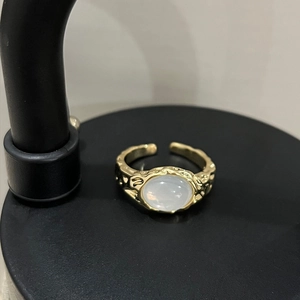 Macro view of gold plated feather ring with hammered texture and white cat eye stone