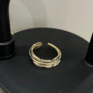 Detailed close-up showing the intricate feather texture of this gold adjustable ring