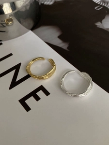 Detailed close-up showing feather texture on gold and silver adjustable open rings