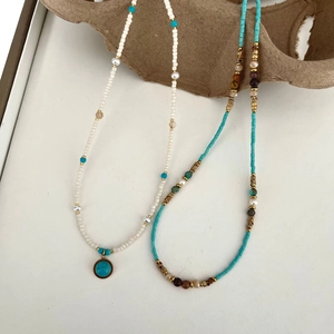 Detail of layered titanium steel necklace with natural stones and freshwater pearls