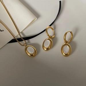 Detailed macro view of 18K gold plated oval white shell necklace and hoop earrings set