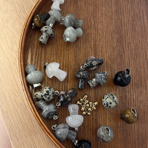 Detailed macro view of rainbow mushroom pendants made of natural stones and gold beads