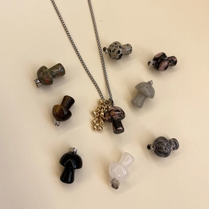 Close-up of rainbow mushroom natural stone pendants with gold metal ring details