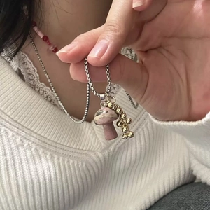 Detail of pink marble mushroom pendant with golden beads on a silver box chain