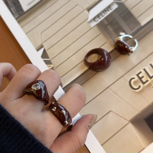 Detail of burgundy enamel rings with silver metal heart accents and glossy chocolate finish