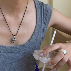 Dettaglio di pendente a fungo in pietra su collana nera e anello in argento