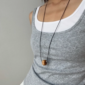 Sautoir minimaliste en cordon ciré avec pendentif en ivoire végétal et billes d'acier