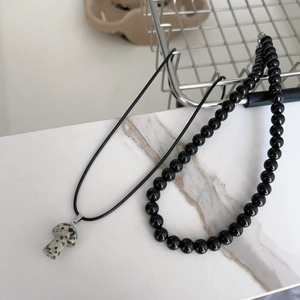 Dettaglio della collana con pendente a fungo in pietra e perline nere lucide