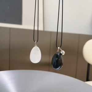 Detailed view of teardrop natural stone pendants in polished white and black finishes