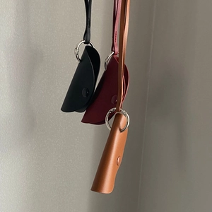 Close-up of three minimalist leather glasses pouches in black, burgundy and tan colors