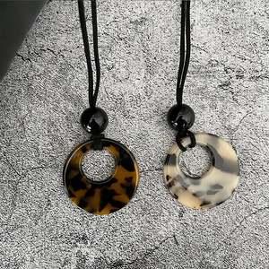 Gros plan de pendentifs ronds en résine aux motifs écaille de tortue et marbre