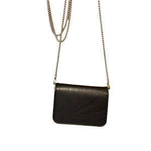 Minimalist black chain crossbody mini square bag with silver metal strap and pebbled texture