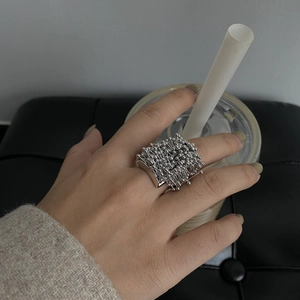 Artistic silver fireworks seed ring shown in a hand-held lifestyle close-up shot