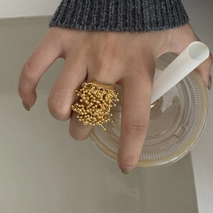 Detailed view of the gold firework seed cluster ring with an artistic textured design