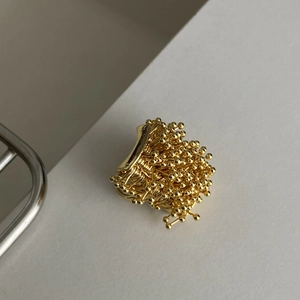 Detail of a vintage-style golden firework cluster ring with intricate wire-wrapped beads