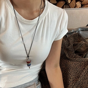 Detail of multi-layered chakra stone pendant with silver metal accents on long black cord