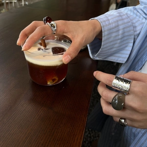 Detail of stacked silver hammered metal ring and colorful resin oval stone rings