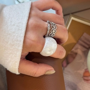 Close-up of three-piece set featuring a wide white resin ring and silver gemstone bands