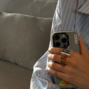 Three-piece ring set with irregular silver metal textures and amber resin on hand