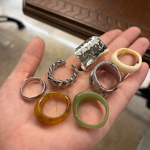 Close-up of a diverse stack of metal and colorful resin rings held in hand