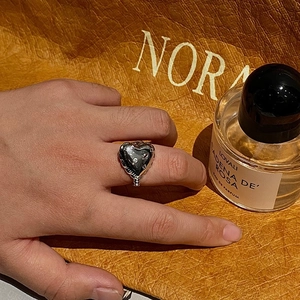 Detailed view of silver heart-shaped resin ring with sparkling zircon accents on finger