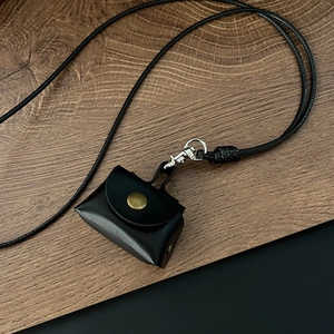 Detail der Mini-Leder-Geldbörse am Halsband mit antikem bronzefarbenem Druckknopf
