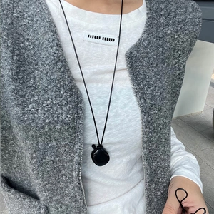 Detailed view of the sleek black abstract heart pendant on a long minimalist cord necklace