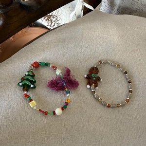 Detail of Christmas beaded bracelets featuring a gingerbread man and a green tree charm